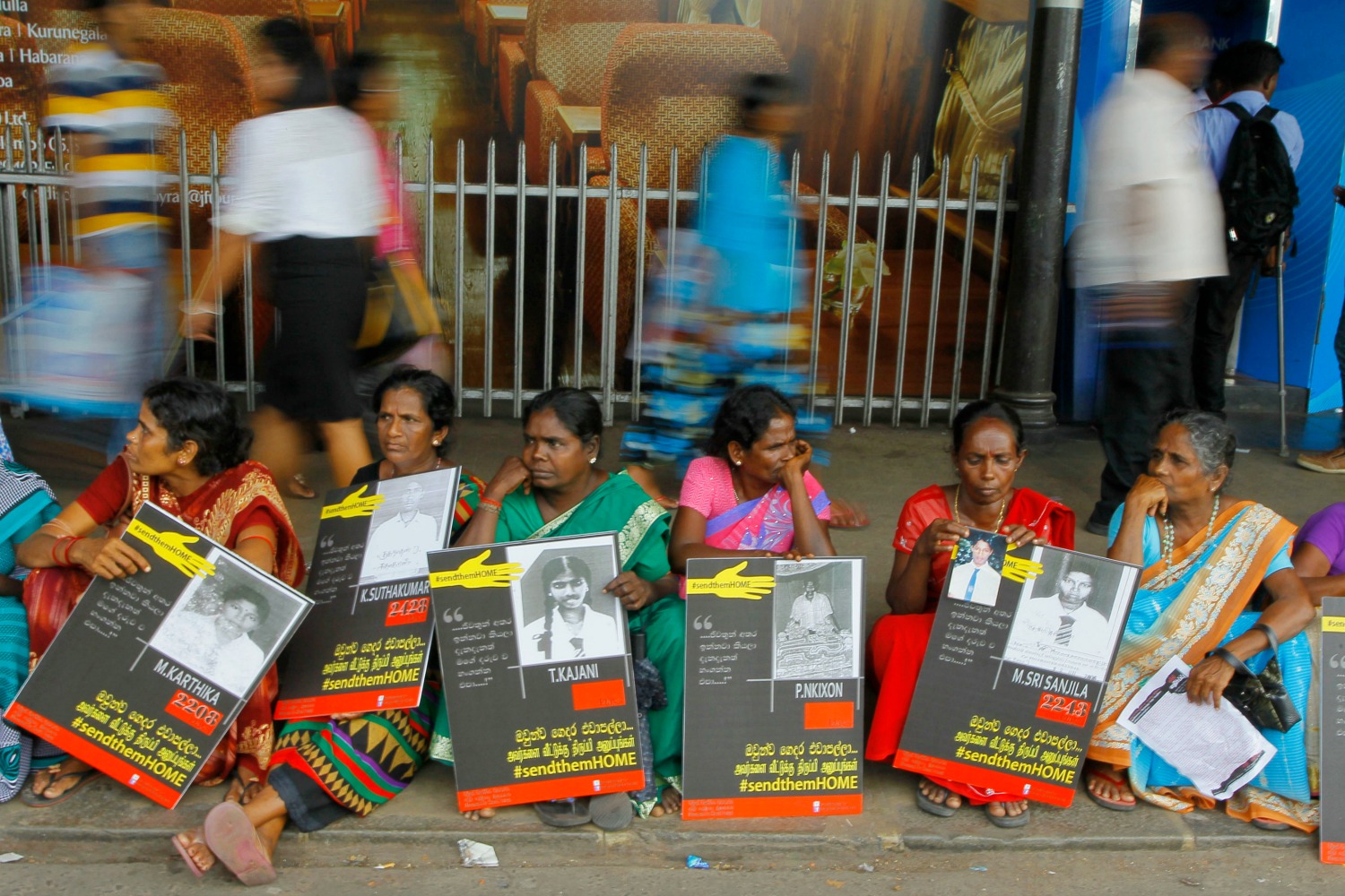 ** HOLD TO GO WITH STORY SLUGGED SRI LANKA SLOWLY HEALING BY KRISHAN FRANCIS**   FILE-In this Monday, April 6, 2015, file photo, Sri Lankan ethnic Tamil women sit holding placards with portraits of their missing relatives as they protest out side a railway station in Colombo, Sri Lanka. Seven years since the end of a brutal civil war, Sri Lanka faces the daunting twin challenges of uniting ethnic communities polarized due to decades of acrimony and violence while also dealing with the divisive issue of addressing war crimes allegations. (AP Photo/Eranga Jayawardena, File)